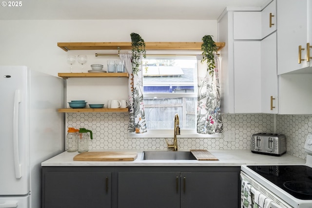 kitchen with light countertops, white appliances, a sink, and tasteful backsplash