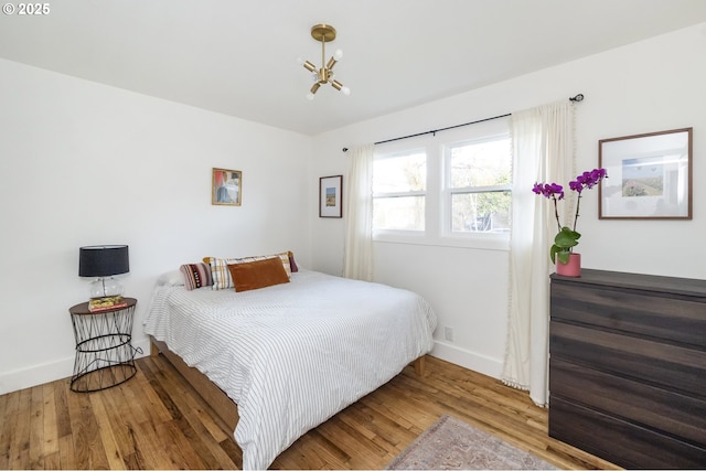 bedroom featuring baseboards and wood finished floors