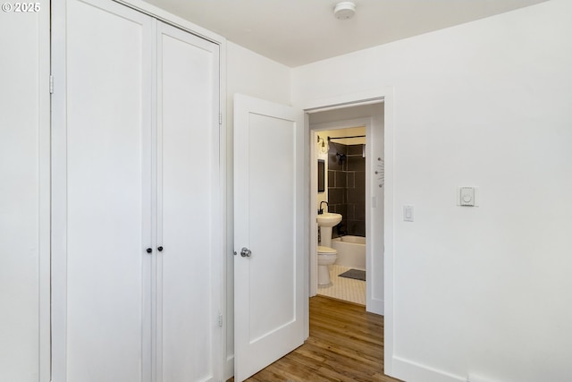 interior space with a sink, wood finished floors, and baseboards