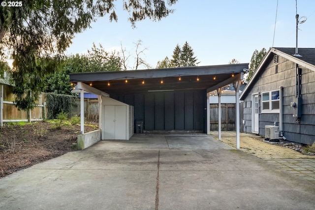 exterior space with a carport, central AC, driveway, and fence