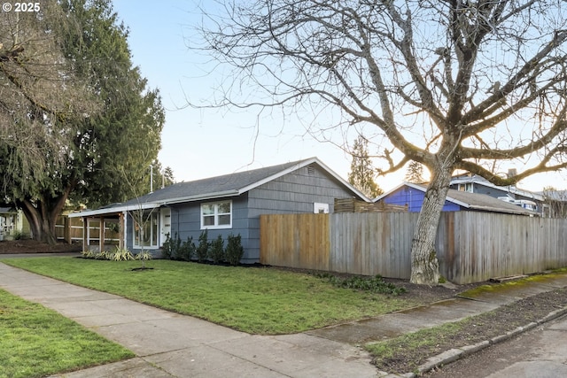 view of front of home featuring fence and a front lawn