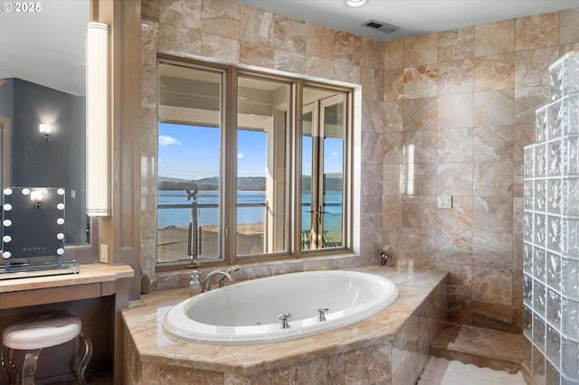 bathroom with shower with separate bathtub and a water view