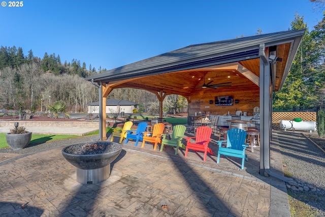 view of patio / terrace with a gazebo, ceiling fan, and an outdoor fire pit