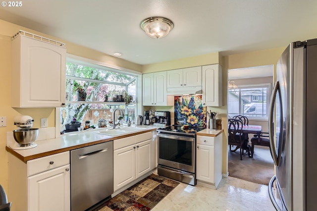 4730 SW 189th Pl, Beaverton, OR 97078 - kitchen with appliances with stainless steel finishes, a sink, light countertops, white cabinets, and under cabinet range hood