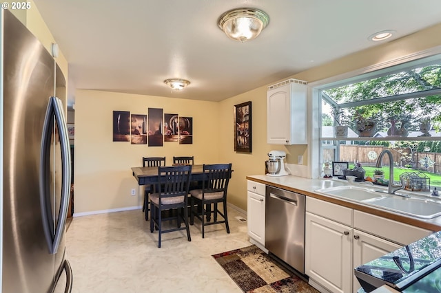 4730 SW 189th Pl, Beaverton, OR 97078 - kitchen featuring a sink, appliances with stainless steel finishes, white cabinets, and baseboards
