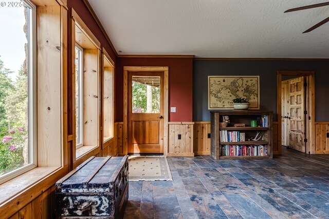 86561 R R Baker Rd, Springfield, OR 97478 - entrance foyer featuring a ceiling fan, dark stone finish floors, wainscoting, and wood walls