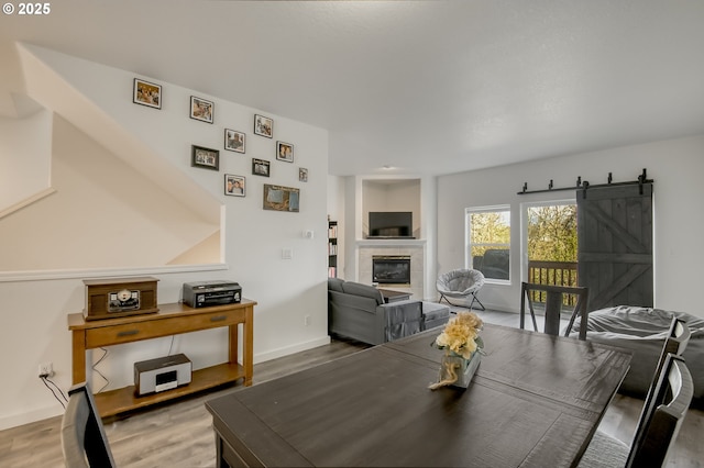 11220 SW Buffalo Pl, Tigard, OR 97223 - dining area featuring wood finished floors, a tiled fireplace, and a barn door