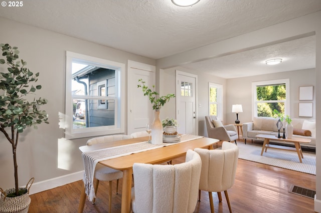 dining space featuring a textured ceiling and dark wood-type flooring