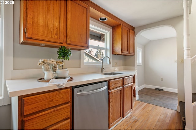 kitchen featuring stainless steel dishwasher, light wood-type flooring, and sink