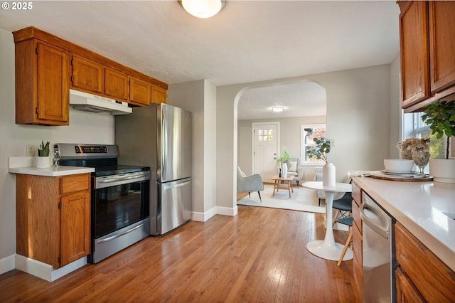 kitchen with light hardwood / wood-style floors, appliances with stainless steel finishes, and a healthy amount of sunlight