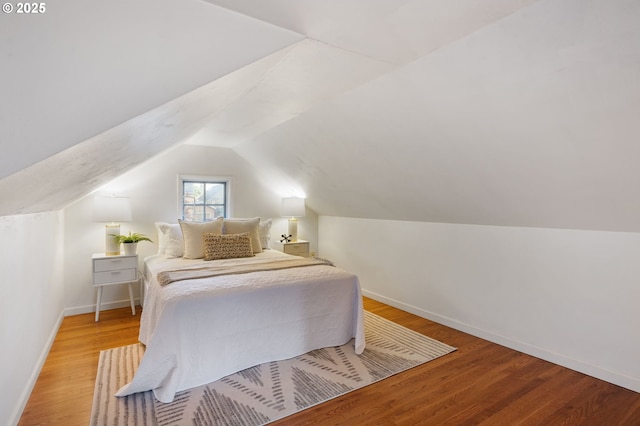 bedroom with lofted ceiling and light wood-type flooring