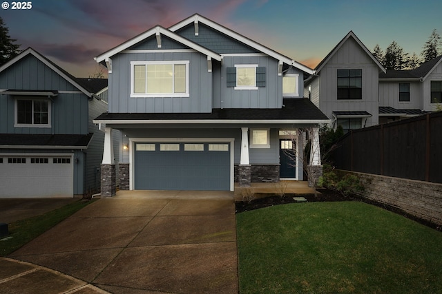 craftsman inspired home featuring board and batten siding, fence, a garage, stone siding, and driveway