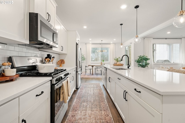 kitchen with a sink, dark wood finished floors, white cabinets, and stainless steel appliances
