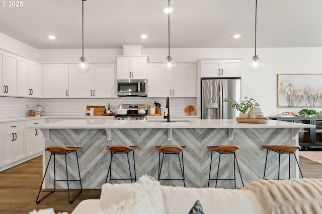 kitchen featuring a sink, light countertops, stainless steel appliances, and wood finished floors