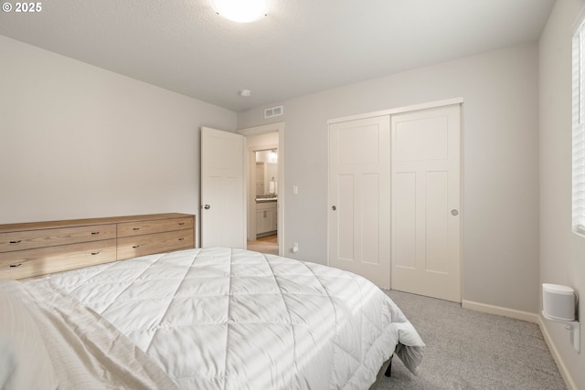bedroom featuring light colored carpet, baseboards, visible vents, and a closet