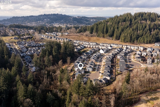 bird's eye view featuring a wooded view, a residential view, and a mountain view