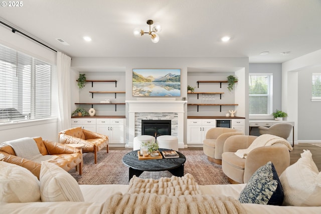 living room with a fireplace, recessed lighting, light wood-style flooring, and visible vents