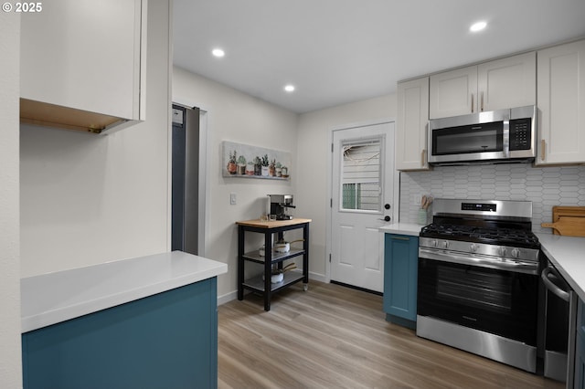 kitchen featuring light countertops, light wood-style floors, backsplash, and stainless steel appliances