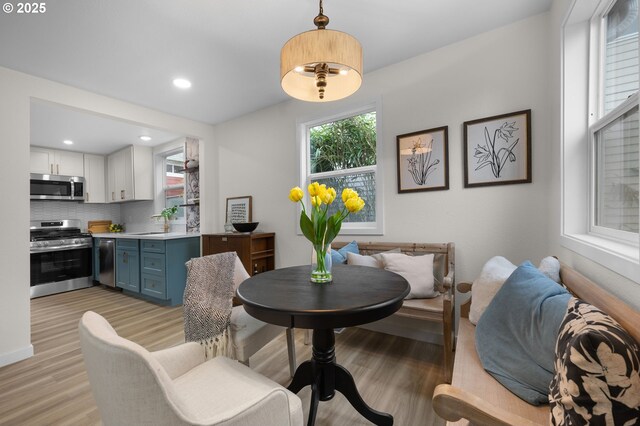 kitchen with stainless steel appliances, light countertops, backsplash, light wood-type flooring, and recessed lighting