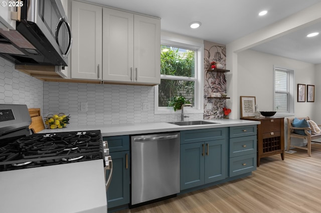 4112 NE 80th Ave, Portland, OR 97218 - kitchen with stainless steel appliances, a sink, light countertops, light wood-style flooring, and recessed lighting