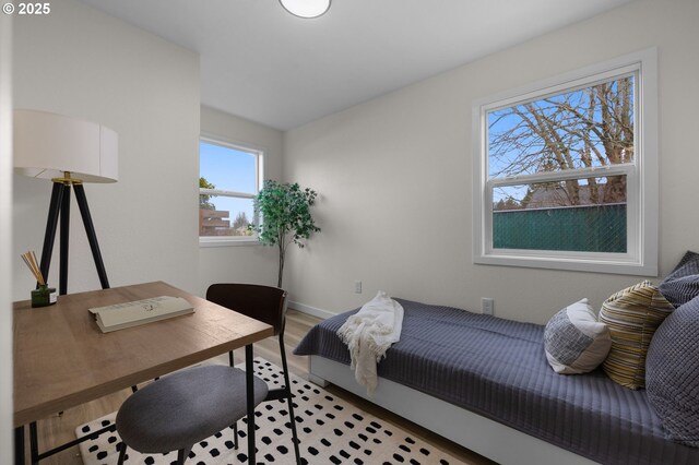bedroom with wood finished floors, a desk, and baseboards