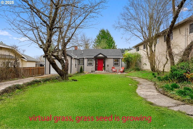 view of front facade with a front yard, fence, driveway, an attached garage, and a chimney