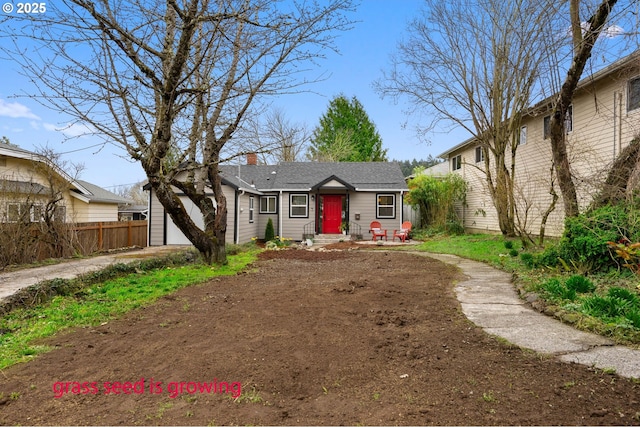 view of front of house with a garage, a chimney, driveway, and fence