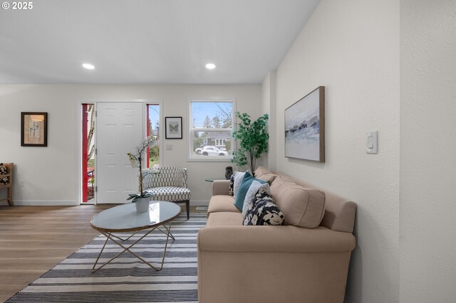 living room featuring healthy amount of natural light, light wood-style floors, recessed lighting, and baseboards