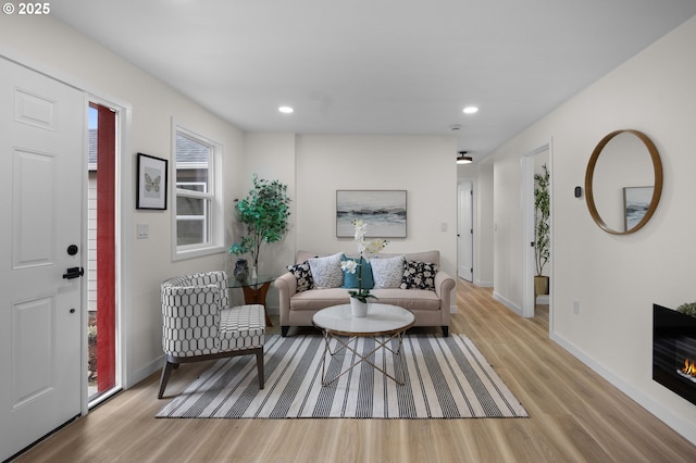 living room featuring recessed lighting, baseboards, and light wood-style floors