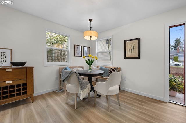 dining room featuring breakfast area, baseboards, and wood finished floors