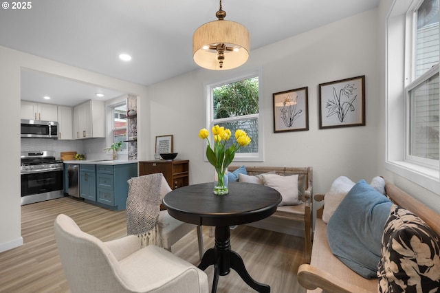 dining space with recessed lighting, an inviting chandelier, and light wood-style flooring