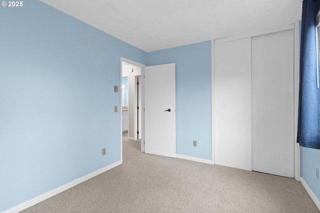 unfurnished bedroom with light colored carpet and a closet