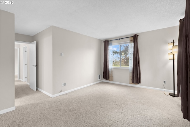 carpeted empty room featuring a textured ceiling