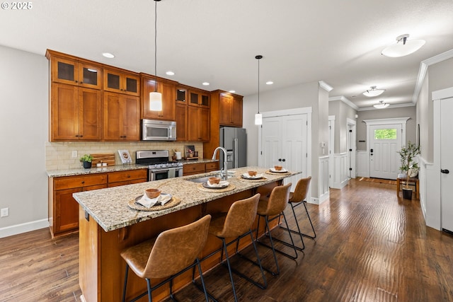 12795 Lindsay Anne Ln, Oregon City, OR 97045 - kitchen featuring stainless steel appliances, a sink, brown cabinetry, decorative backsplash, and baseboards