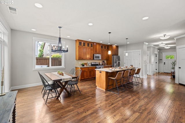 12795 Lindsay Anne Ln, Oregon City, OR 97045 - kitchen with brown cabinets, appliances with stainless steel finishes, recessed lighting, healthy amount of natural light, and an island with sink