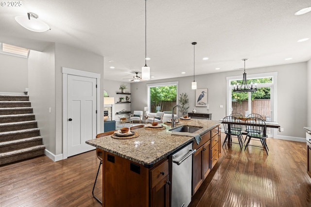 12795 Lindsay Anne Ln, Oregon City, OR 97045 - kitchen featuring a sink, dishwasher, dark wood-style flooring, a breakfast bar, and a center island with sink