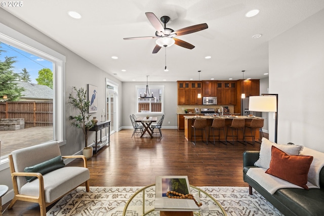 12795 Lindsay Anne Ln, Oregon City, OR 97045 - living room with recessed lighting, ceiling fan, dark wood-style flooring, baseboards, and a chandelier