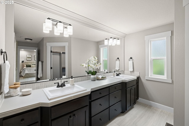 12795 Lindsay Anne Ln, Oregon City, OR 97045 - ensuite bathroom with double vanity, baseboards, and decorative backsplash