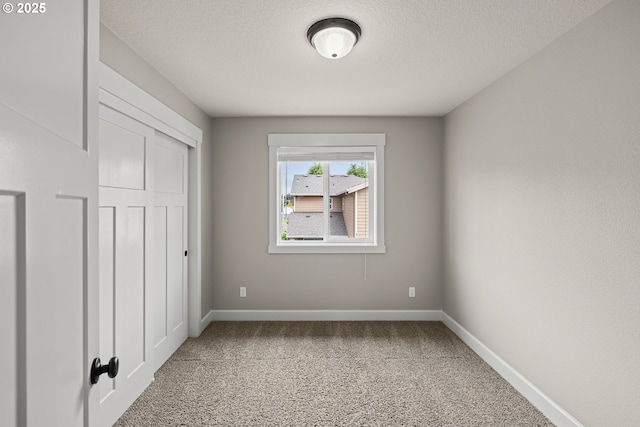 12795 Lindsay Anne Ln, Oregon City, OR 97045 - unfurnished bedroom with carpet floors, baseboards, a textured ceiling, and a closet