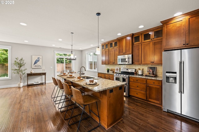 12795 Lindsay Anne Ln, Oregon City, OR 97045 - kitchen with stainless steel appliances, a sink, brown cabinetry, recessed lighting, and dark wood finished floors