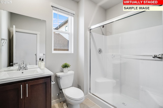 full bath featuring a shower stall, vanity, baseboards, and toilet