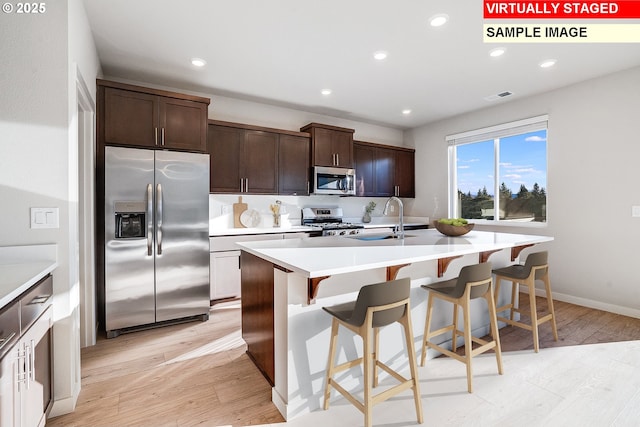 kitchen with light wood-style flooring, visible vents, recessed lighting, appliances with stainless steel finishes, and a sink