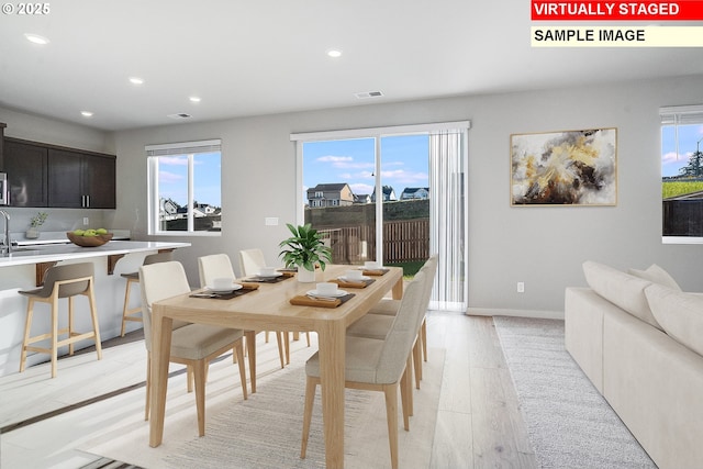 dining room featuring recessed lighting, light wood-style flooring, and a healthy amount of sunlight