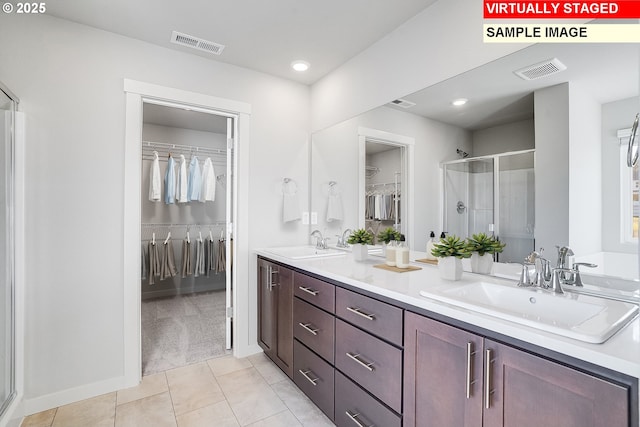 bathroom with a sink, visible vents, and a shower stall