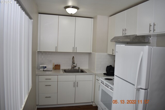 kitchen featuring white appliances, white cabinetry, backsplash, and sink