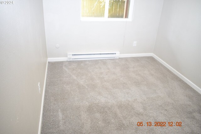 empty room with baseboard heating and carpet flooring