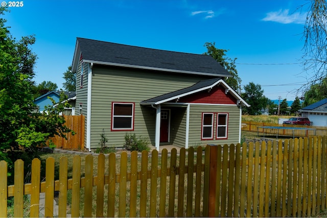 bungalow-style house with roof with shingles, fence private yard, and a trampoline