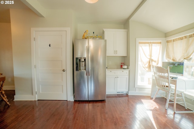 kitchen with white cabinets, stainless steel fridge, baseboards, wood finished floors, and vaulted ceiling