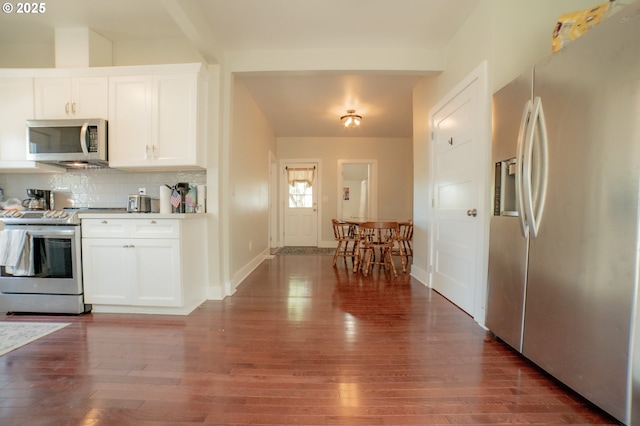 kitchen with dark wood-style flooring, appliances with stainless steel finishes, and white cabinetry