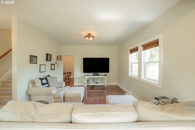 living area featuring baseboards, stairs, and wood finished floors